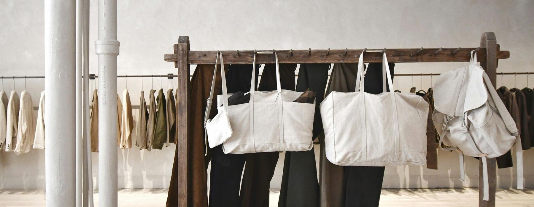 a row of clothes and bags on a rack